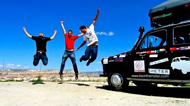 three men jumping by a taxi